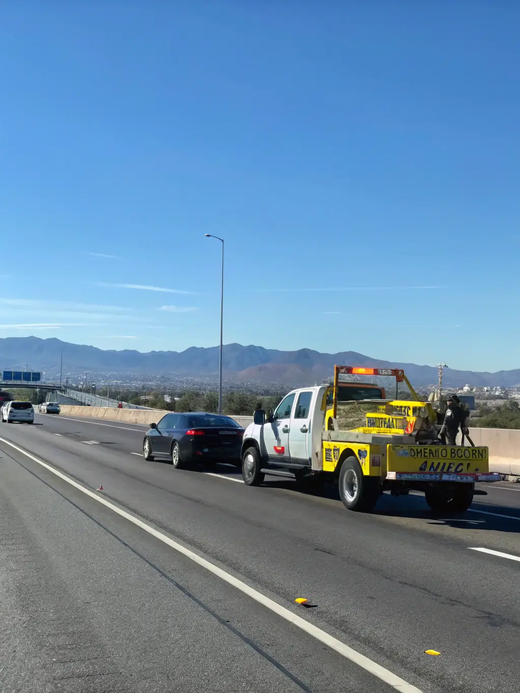 A specialized flatbed tow truck carefully transporting a luxury sports car, demonstrating the care and precision for high-value vehicles.